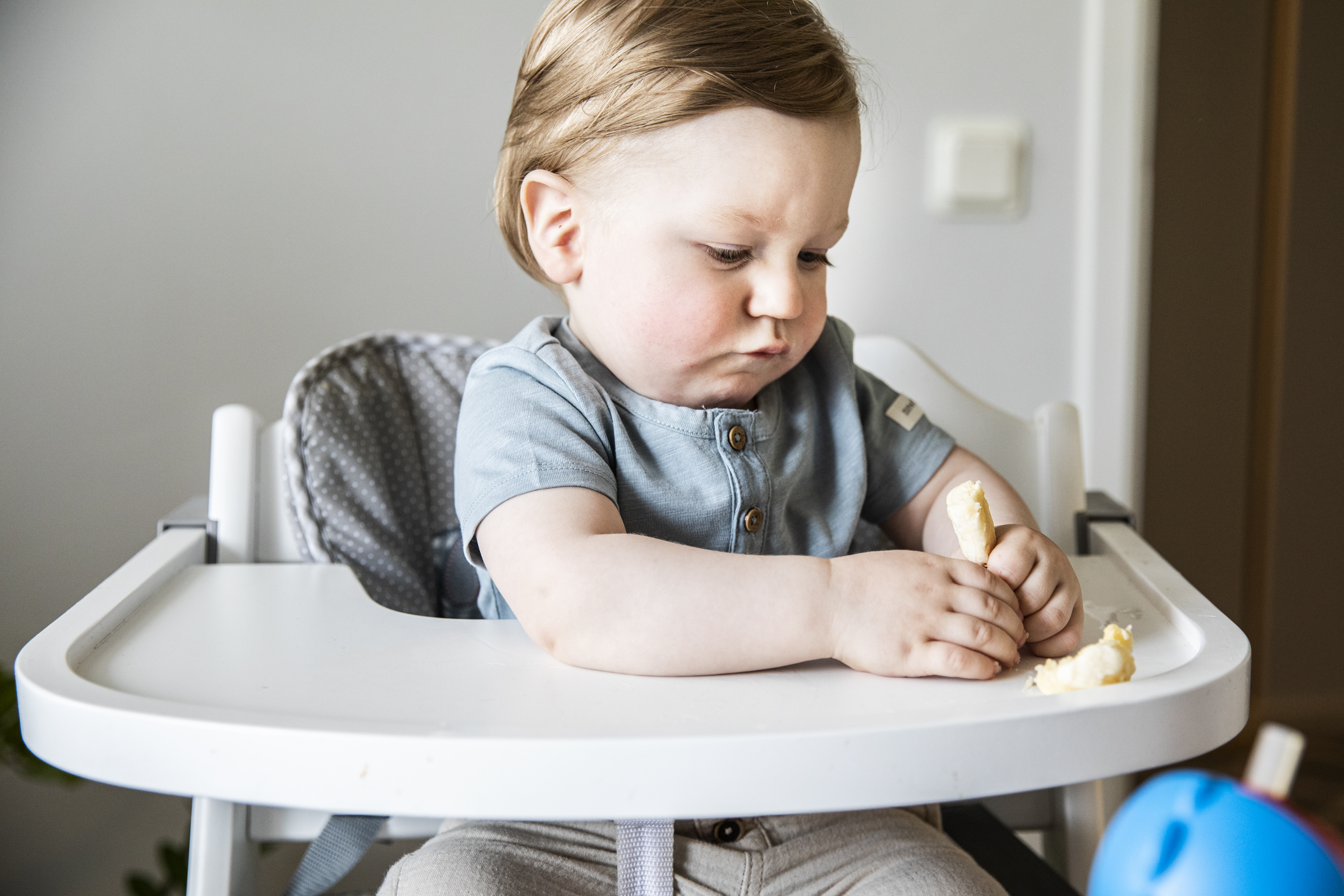 1 åring som mosar en banan med sin händer.