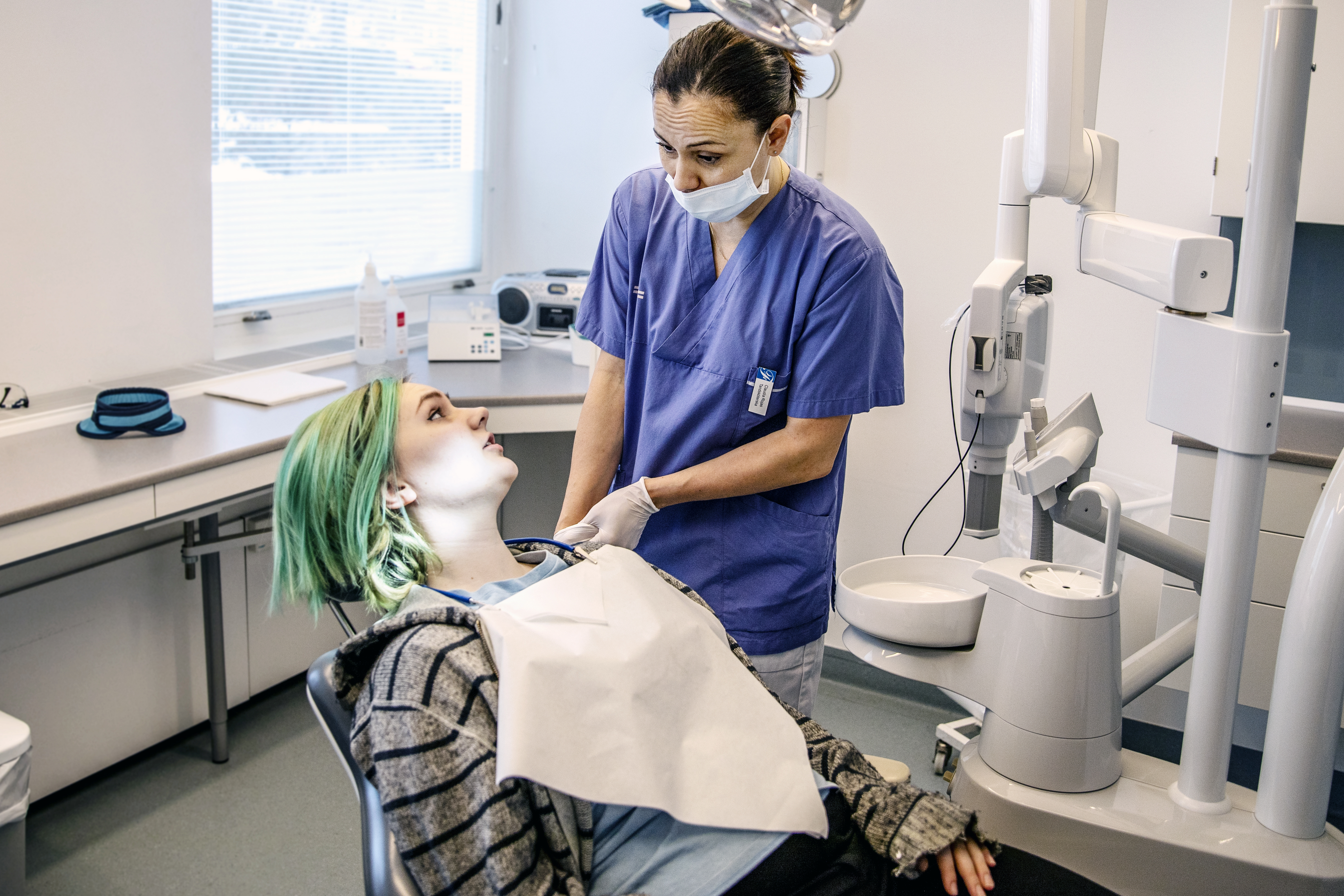 Tandhygienist och patient som pratar med varandra.