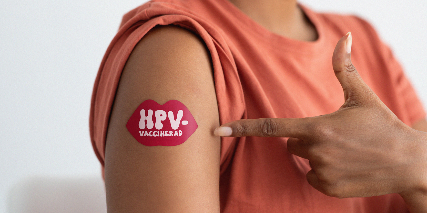 Arm med plåster som det står HPV-vaccinerad på.